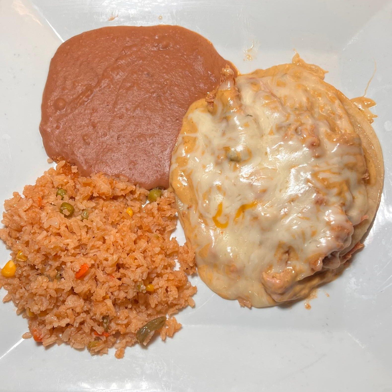34. 3 green flat chicken enchiladas topped with melted cheese, and served with rice and beans.
